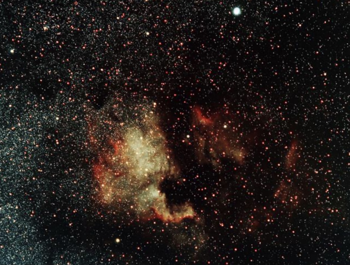 A dense red and gold star field showing the North America Nebula